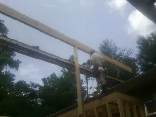 Carpenter setting a ridge beam over a new addition frame — Ice Dam Removal by Roofing Brothers in Hainesport