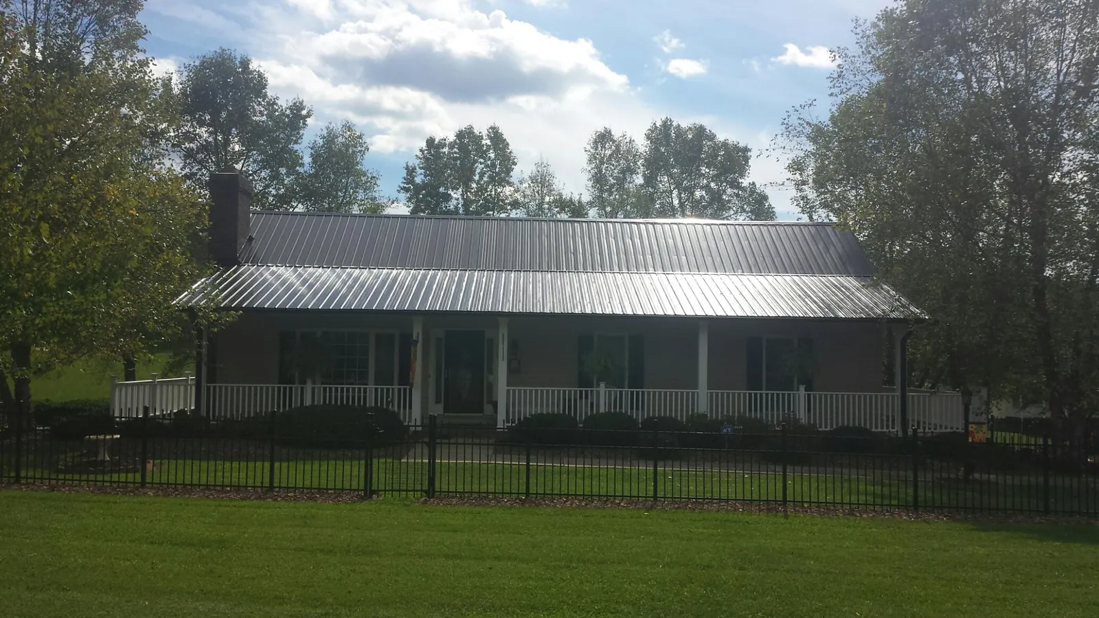 Gray metal roof on a brick ranch with a full width front porch — Gutter Guard Installation work by our crew in Hainesport