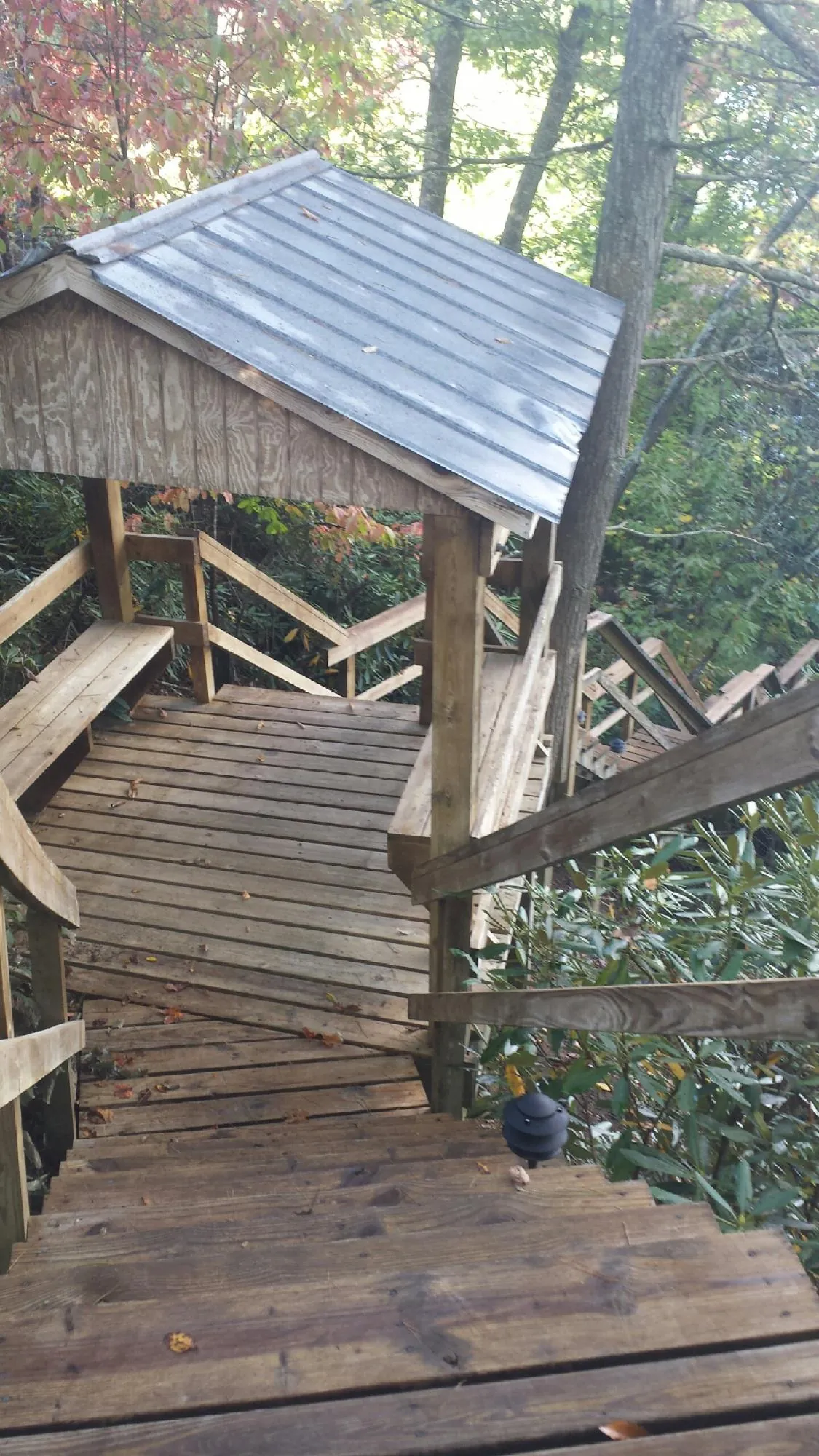 Metal roofed shelter over wooden steps on a wooded walkway — Skylight Repair & Installation work by our crew in Hainesport